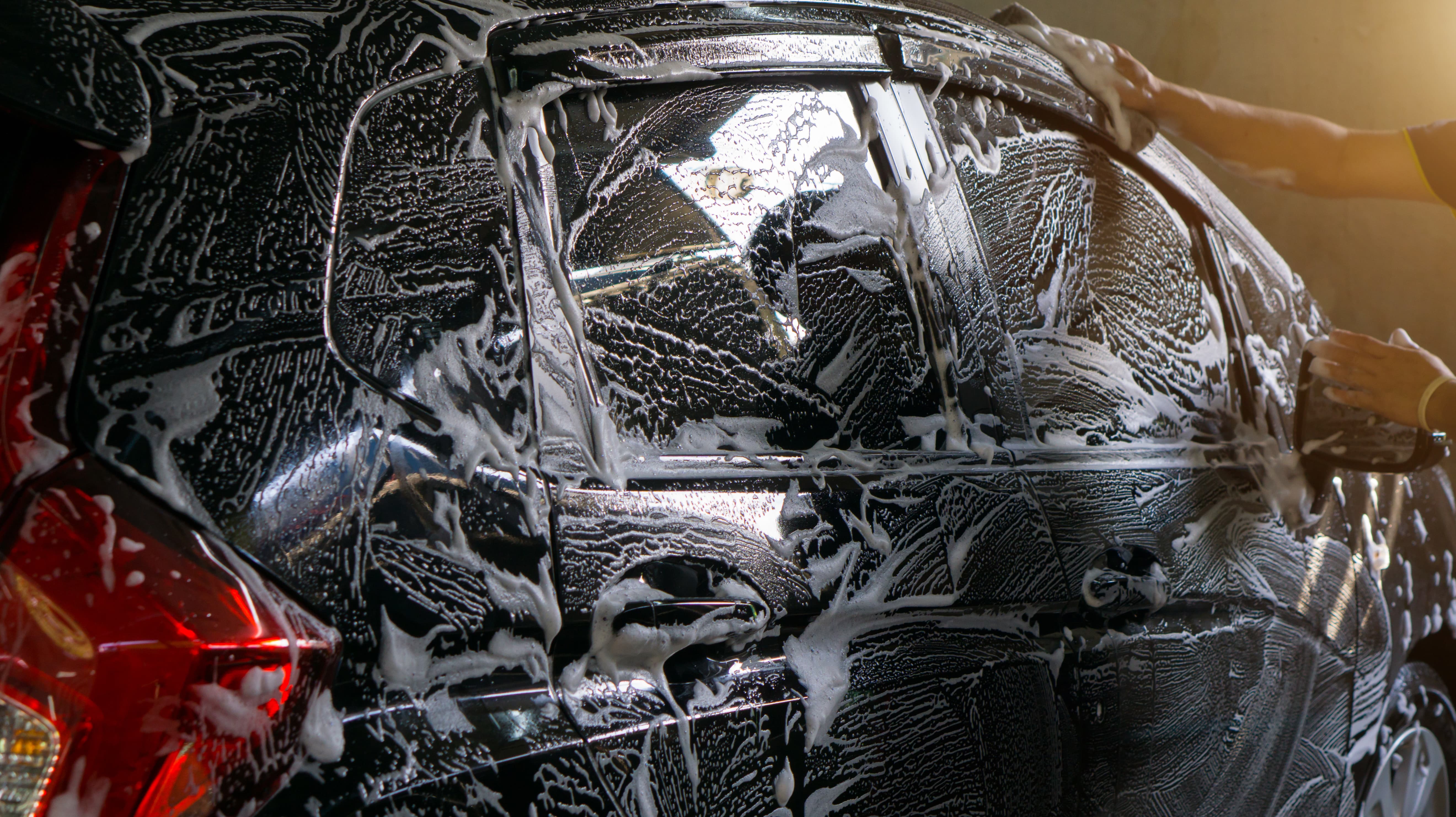 Car covered in thick detailing foam during a hand wash